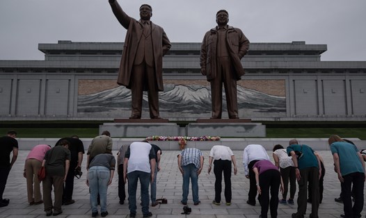 Du khách cúi đầu trước hai bức tượng nhà lãnh đạo Kim Nhật Thành và Kim Jong-il ở thủ đô Bình Nhưỡng. Ảnh: NRP