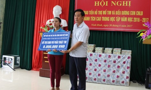 Ông Dương Đức Khanh - Chủ tịch LĐLĐ Ninh Bình trao quà hỗ trợ phẫu thuật tim cho đại diện gia đình. Ảnh: H.N