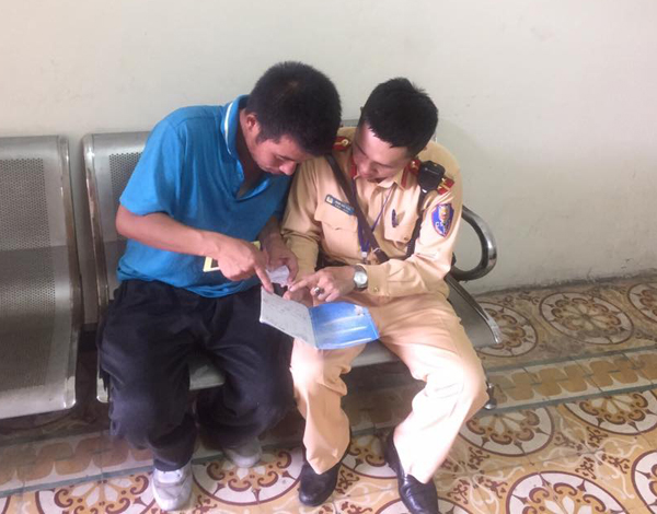 Cảnh sát giao thông tận tình giúp đỡ anh Ma Xiangle. Ảnh Quốc Sang