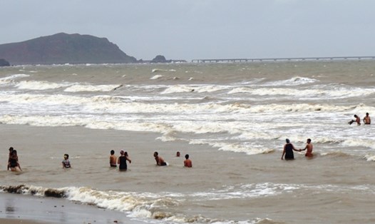 Sáng 17.7, bất chấp nguy hiểm, nhiều du khách, trong đó có trẻ em, vẫn tắm biển Cửa Lò. Ảnh: QĐ