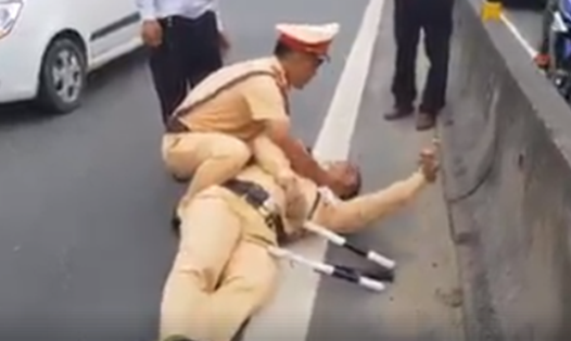 Thượng úy Nguyễn Anh Đức bị hất văng xuống đường đã ngất xỉu. Ảnh: CTV