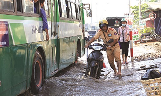 CSGT dắt xe cho người dân trên đoạn đường ngập nước. Ảnh: Trường Sơn
