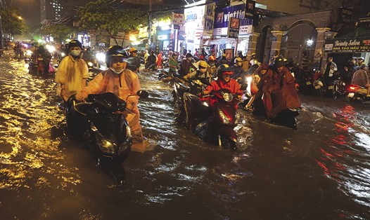 Cơn mưa chiều tối 20.5, gây ngập nặng nhiều khu vực tại TPHCM, khiến người dân phải bì bõm đẩy xe lội nước về nhà - chụp trên đường Nguyễn Xí. Ảnh: M.Q