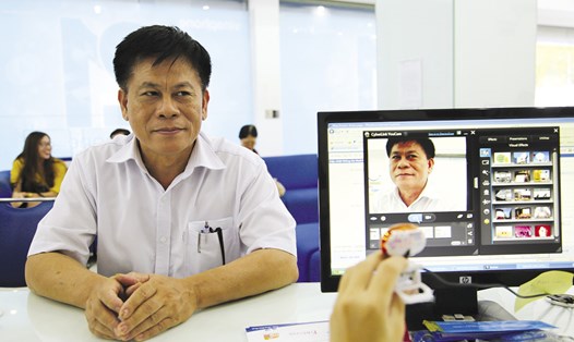 Nhân viên một nhà mạng đang chụp ảnh chân dung cho một người dân đến đăng ký thuê bao di động. Ảnh: Ngọc Tiến