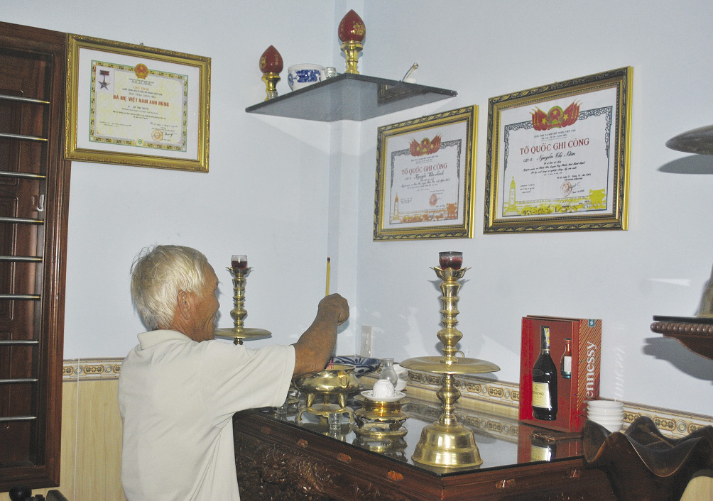 Ông Thừa thắp nén nhang lên bàn thờ ông bà. Ảnh: P.N