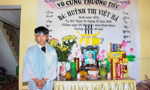 Cậu bé Nguyễn Hoàng Vũ, đứng trước bàn thờ và di ảnh của mẹ...Ảnh TT