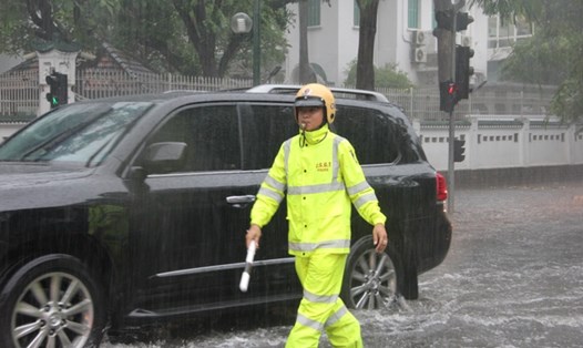Cảnh sát giao thông dầm mưa, lội nước điều khiển, phân luồng giao thông.