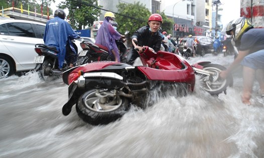 Xe máy ngã, trôi trong mưa trên đường Võ Văn Ngân.  Ảnh: M.Q