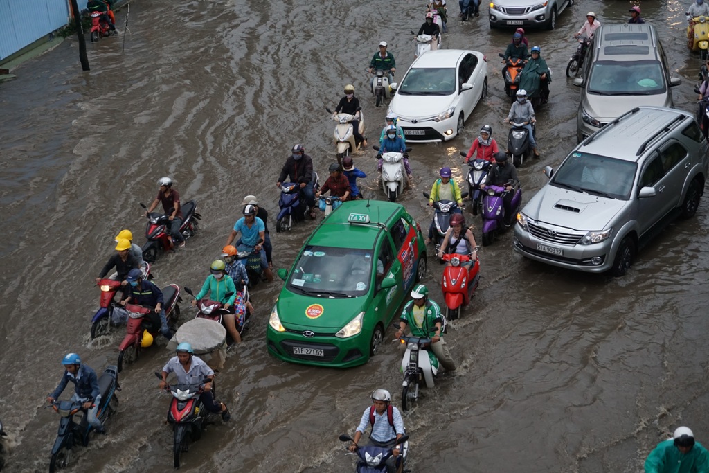 Đường Nguyễn Hữu Cảnh ngập lênh láng. Hàng trăm xe cộ chen chúc nhau vượt qua điểm ngập.   Ảnh: M.Q