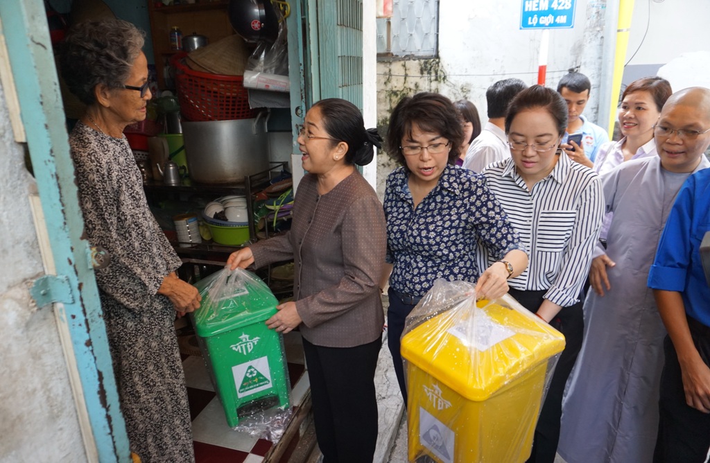 Phó Bí thư Thành ủy Võ Thị Dung (thứ hai từ trái qua) tặng thùng rác cho các hộ gia đình. Ảnh: M.Q