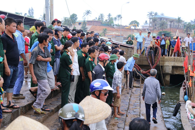  Người dân và chính quyền địa phương ở cảng cá Cửa Tùng đón 44 người gặp nạn về đất liền. Ảnh: HƯNG THƠ 