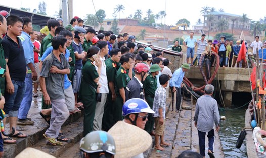  Người dân và chính quyền địa phương ở cảng cá Cửa Tùng đón 44 người gặp nạn về đất liền. Ảnh: HƯNG THƠ 