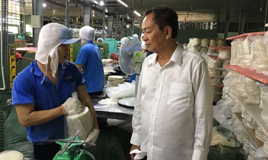 Ông Phạm Văn Tứ (áo trắng) và công nhân Công ty Thuận Phong đang sản xuất bánh tráng xuất khẩu sang Mỹ. Ảnh: C.H
