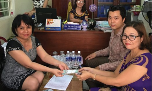 Bà Phan Thị Thục Anh (bên trái) - Giám đốc Quỹ Trợ vốn TP.Đà Nẵng - trao vốn vay cho người lao động. Ảnh: NGỌC YẾN