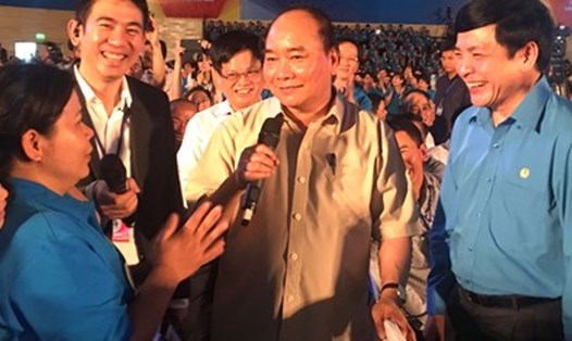 Thủ tướng Chính phủ Nguyễn Xuân Phúc trao quà hỗ trợ cho 20 CN có hoàn cảnh khó khăn tại buổi đối thoại với 2.000 công nhân vùng kinh tế trọng điểm miền Trung. Ảnh: H.L